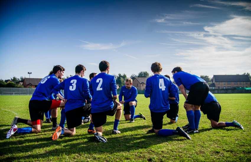 soccer team taking a knee