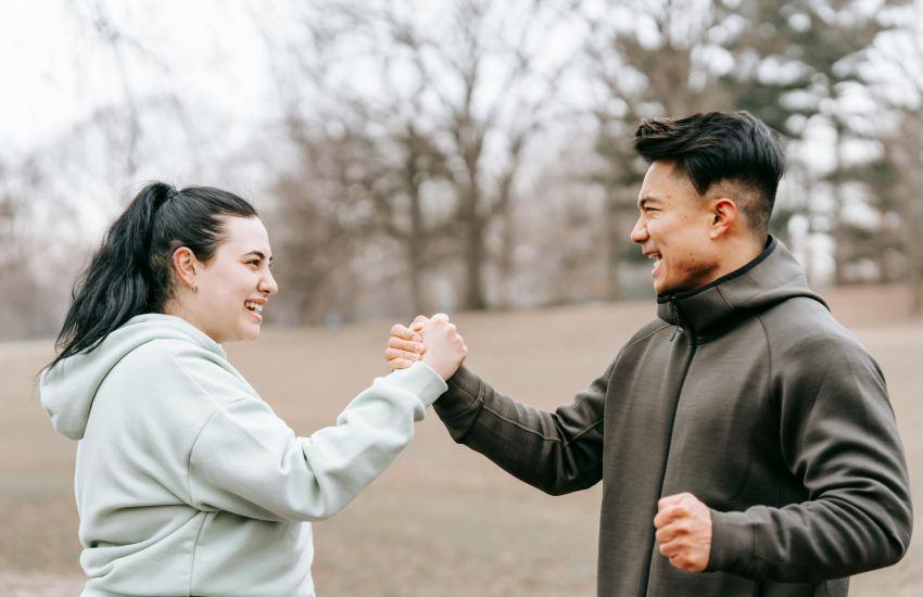 two people in activewear high-fiving